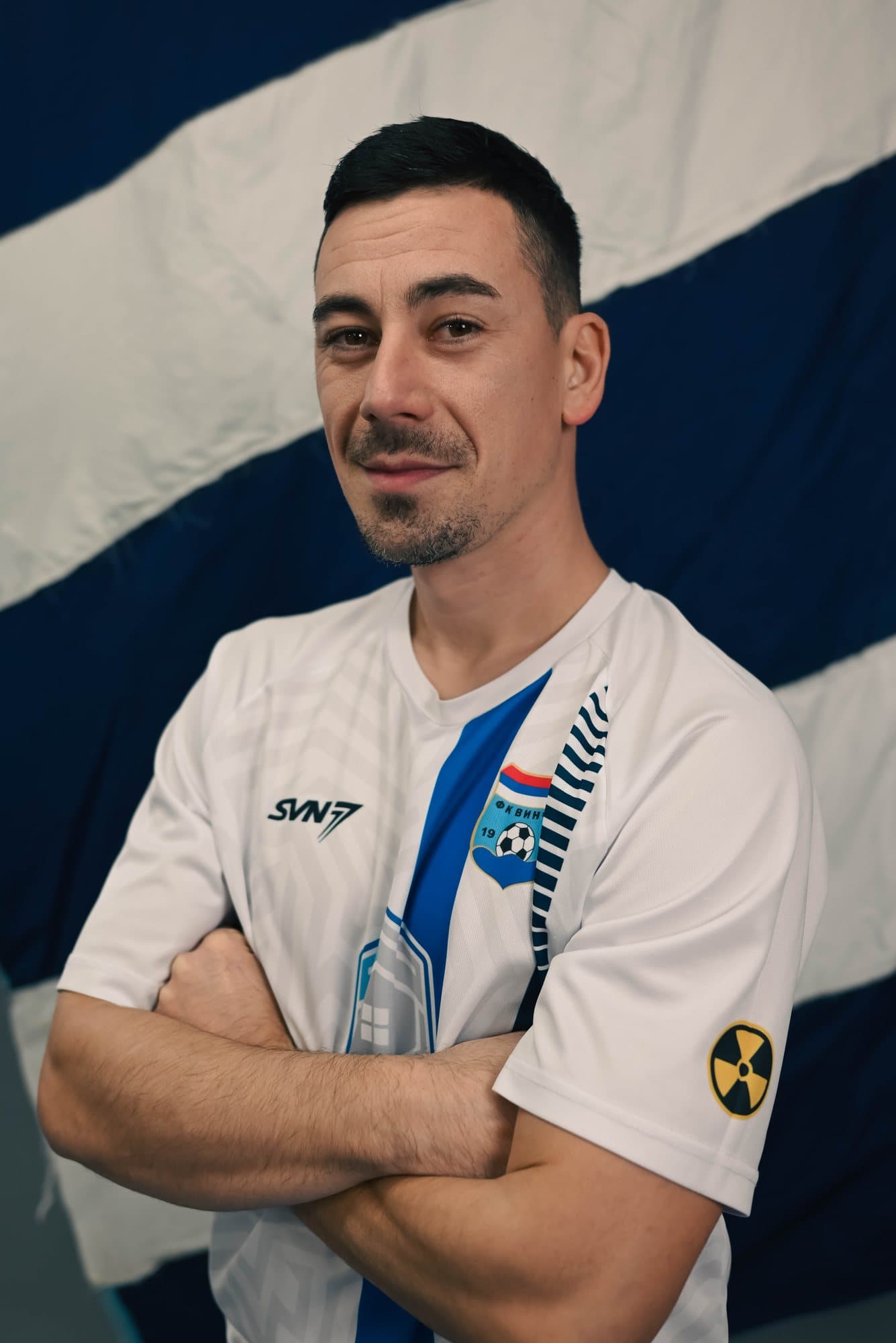 Igor ispred zastave kluba, ruke prekrštene